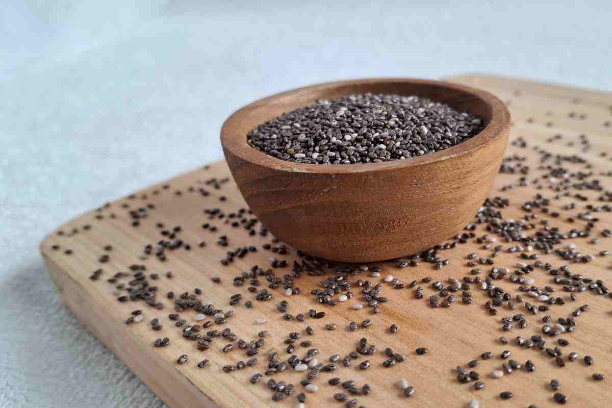 semi di chia in una ciotola poggiata su un piano di legno