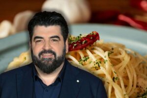 spaghetti aglio, olio e peperoncino nel piatto e antonino cannavacciuolo sorridente